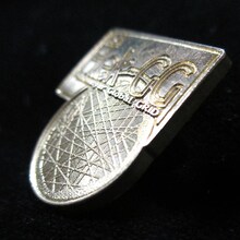 「真鍮ピンバッジセット」のHek-GGマーク。 (C)2012 高橋慶太郎・小学館／ヨルムンガンド製作委員会