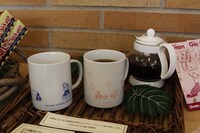 「ルピシアオリジナルブレンド どら焼きフレーバーホットティー」。左のカップにお湯を入れると、右のように絵柄が変化する。マグカップ付きが1500円、なしが600円。(C)Fujiko-Pro