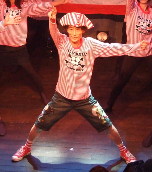 腕を振り上げ踊る楳図かずお。