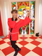 まことちゃんの団扇を両手に、笑顔の楳図かずお。