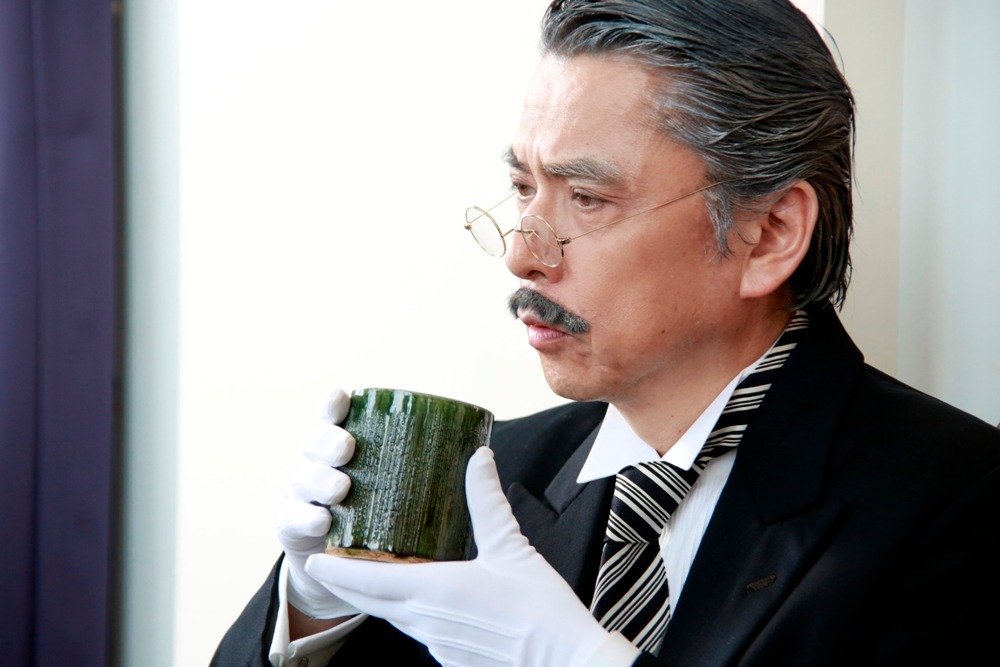 志垣太郎演じる田中。幻蜂家老執事。どんな騒動が起ころうと、いつものどかにお茶を飲んでいる、幻蜂家の安らぎ。湯呑みの中はレモネード。 (c)2014 枢やな／スクウェアエニックス (c)2014 映画「黒執事」製作委員会