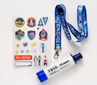 「宇宙兄弟」22巻限定版に付属する天体望遠鏡、ネックストラップ、シール。