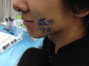 藤村によって顔面にサインされるスクウェア・エニックスの社員。