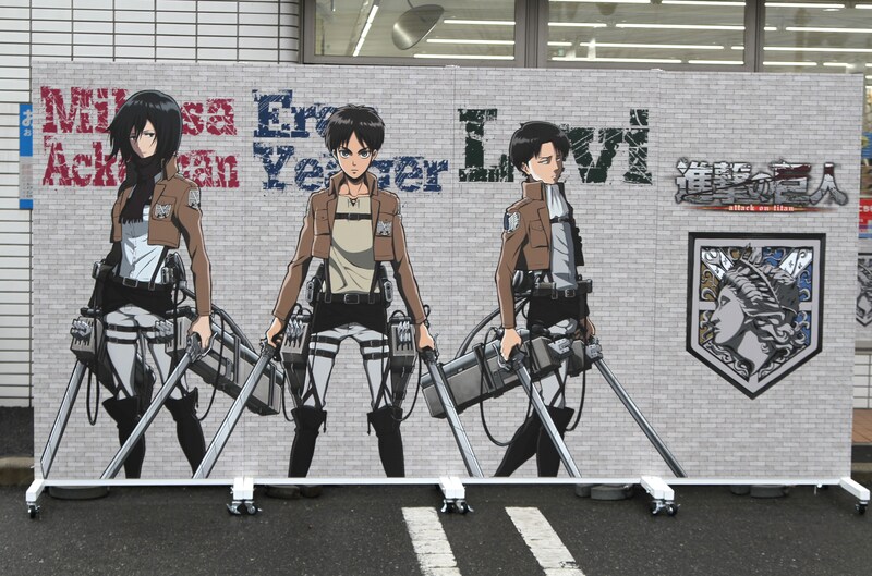 エレン、リヴァイ、ミカサが並んだ「巨大ウォール」。裏面には3人の中から1人をフィーチャーしたイラストがあしらわれている。