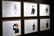 アナログで描かれた線画と、デジタル着彩された完成イラストがセットで展示されている。