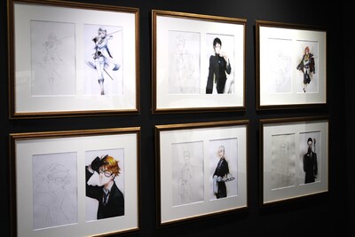 アナログで描かれた線画と、デジタル着彩された完成イラストがセットで展示されている。