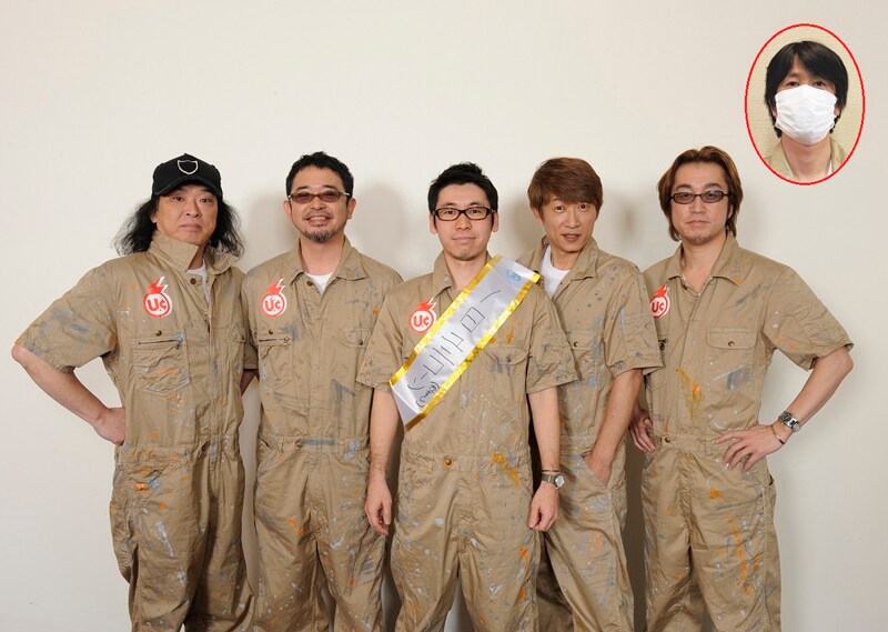 写真中央はユニコーン側より「一日ユニコーン」のたすきとお揃いのつなぎをプレゼントされた小山宙哉。写真右上枠内は、体調不良で欠席したユニコーンEBI。