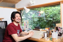 机の正面に「SRS-X3」を置くうすた京介。ワイヤレスのため設置場所を選ばず、様々な作業環境にマッチする。