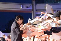 ファンからのサインに応じる佐藤健。