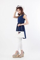 「怪盗キッドモデルパーティーバッグ」をモデルが持った様子。(c)青山剛昌/小学館・読売テレビ・TMS 1996