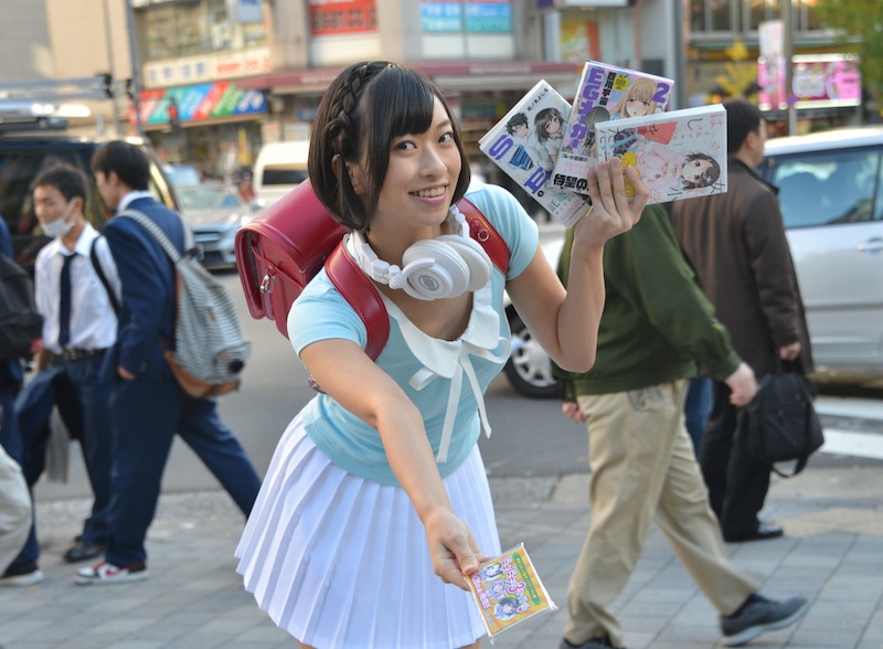 各作品にちなんだ格好で、ティッシュを配る倉持由香。