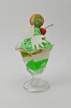 「『ハイエロファントグリーン（法皇の緑）』メロンパフェ チェリー付き」(c)荒木飛呂彦＆LUCKY LAND COMMUNICATIONS/集英社・ジョジョの奇妙な冒険SC製作委員会