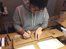 全巻収納ボックスにイラストを描く小山宙哉。※販売される収納ボックスには、描き下ろしイラストが段ボールに印刷されている。