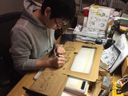 全巻収納ボックスにイラストを描く小山宙哉。※販売される収納ボックスには、描き下ろしイラストが段ボールに印刷されている。
