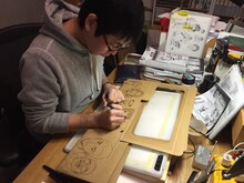 全巻収納ボックスにイラストを描く小山宙哉。※販売される収納ボックスには、描き下ろしイラストが段ボールに印刷されている。