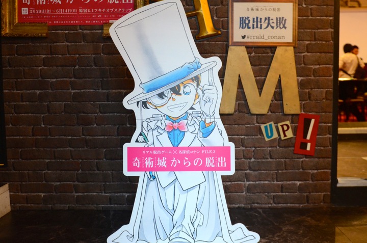 原宿ヒミツキチオブスクラップの入り口で出迎えるコナン。