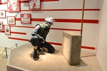 「連載完結記念 岸本斉史 NARUTO－ナルト－展」に設置された慰霊碑を前に佇むカカシの等身大フィギュア。(c)岸本斉史 スコット / 集英社