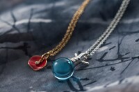 （左から）「薔薇ネックレス 蔵馬モデル」と「氷泪石ネックレス 飛影モデル」原作/冨樫義博「幽☆遊☆白書」(集英社「ジャンプコミックス」刊) (c)Yoshihiro Togashi 1990年-1994年 (c)ぴえろ/集英社