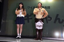 「心臓を捧げよ！」のポーズをする石川由依とスギちゃん。