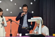 ライブドローイング中の窪之内英策と、その様子を見つめるアダチケイジ。