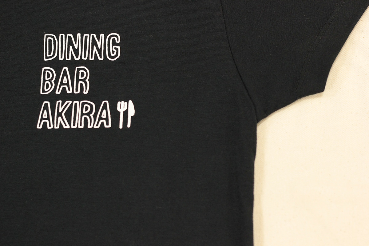 「くいもの処 明楽」のTシャツ。
