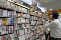 エンターブレインの棚を眺めながら、ビームコミックスの装丁や隣のサブカルコーナーとの相性について考える奥村編集総長。