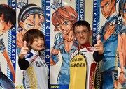 新開隼人のバキュンポーズを決める八木菜緒アナウンサーと渡辺航。ポスターは八木アナウンサーの私物。