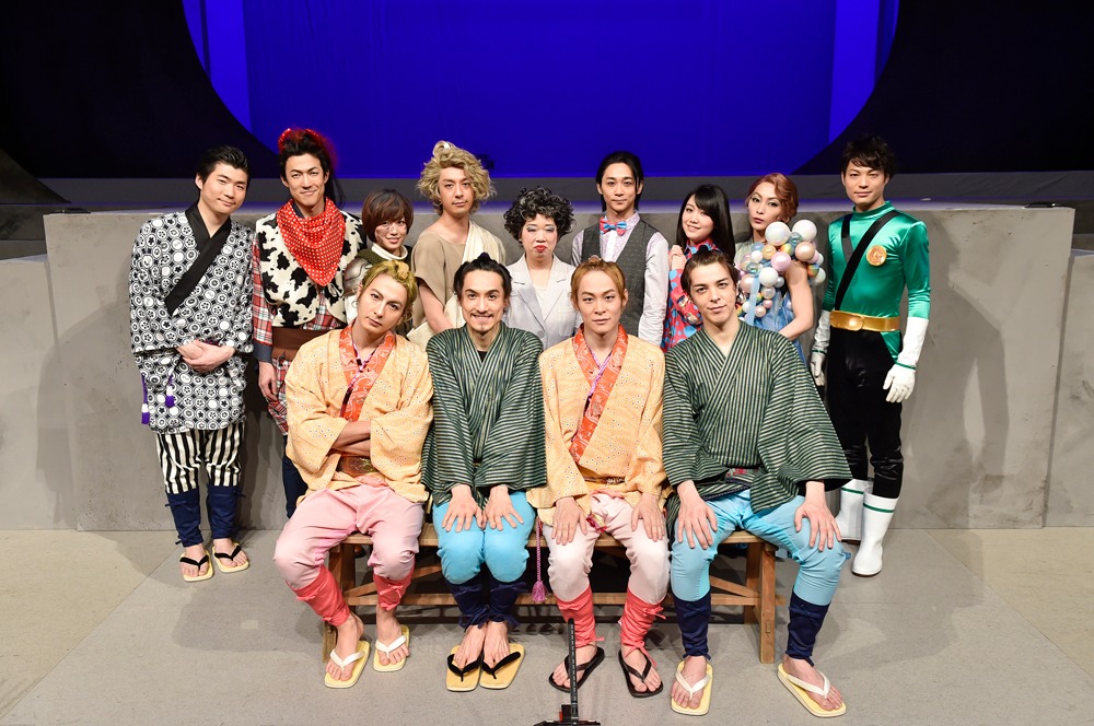 （前列左より）日替わりキャストの藤田玲、弥次さん役の唐橋充、喜多さん役の藤原祐規、うその弥次さん役の汐崎アイル。（後列左より）乗務員役の田代哲哉、紅牛役の西山丈也、ジャンヌダルク役の富田麻帆、空の守役の松本寛也、奪衣婆役の伊藤修子、バーテンダー役の三上俊、バーテンダーの妻役の田上真里奈、あぶくの女／お雪役の岡田あがさ、Gロッソマングリーン役の松本祐一。 撮影：鏡田伸幸