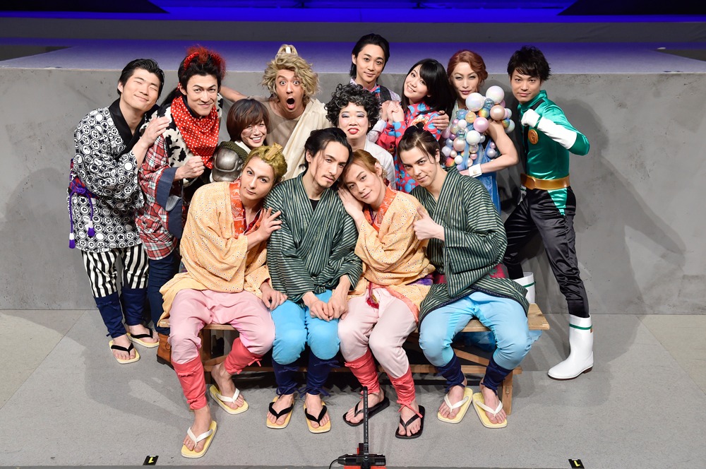 （前列左より）日替わりキャストの藤田玲、弥次さん役の唐橋充、喜多さん役の藤原祐規、うその弥次さん役の汐崎アイル。（後列左より）乗務員役の田代哲哉、紅牛役の西山丈也、ジャンヌダルク役の富田麻帆、空の守役の松本寛也、奪衣婆役の伊藤修子、バーテンダー役の三上俊、バーテンダーの妻役の田上真里奈、あぶくの女／お雪役の岡田あがさ、Gロッソマングリーン役の松本祐一。 撮影：鏡田伸幸