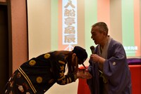 入船亭扇辰と握手をする小林ゆう。