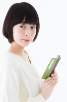 松陽先生の本モデル スマートフォンケースを手にする様子。