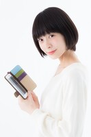 松陽先生の本モデル スマートフォンケースを手にする様子。