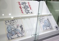 展示スペースに並ぶ神山健治と西尾鉄也の色紙。