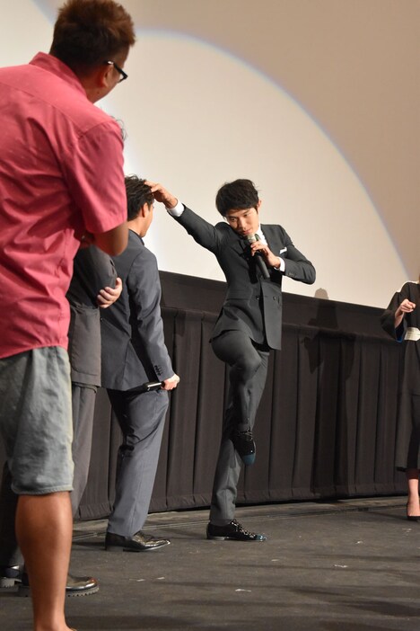 フラミンゴの動きを取り入れたアクションを見せる鈴木亮平。