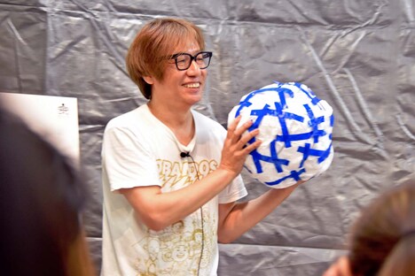 イラストを描いていた紙で、シンボルマークのモチーフを制作してみせたしりあがり寿。