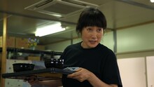 余貴美子演じる飲食店の女将。