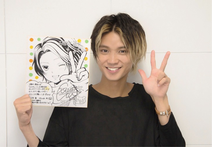 池山田剛直筆のイラストを手にする磯村勇斗。