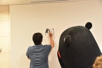 自分のイラストを心配そうに見つめるくまモン。