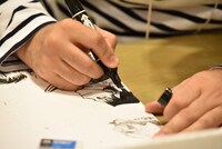 「くまモン頑張れ絵」を描く雷句誠。