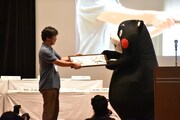くまモンに「くまモン頑張れ絵」を手渡す森川ジョージ。