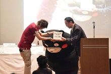 義援金を手渡す真島ヒロ。