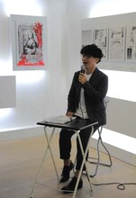 坂本眞一。後ろには、赤く染まった「王妃アントワネット、モナリザに逢う」の1ページが。