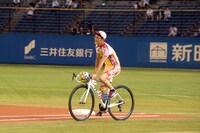 ロードバイクに乗ってマウンドに向かう渡辺航。