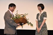 花束を受け取った片渕須直(左)と、のん(右)。