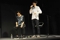 おもむろにシャツを脱ぎだす林士平氏（右）。