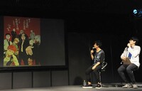 加藤和恵によるイラストを眺める岡本と林氏。