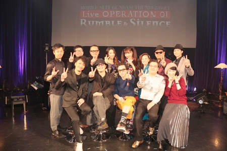 「MOBILE SUIT GUNDAM THUNDERBOLT Live OPERATION 01 “Rumble＆Silence”」の出演者。後列左から服部正嗣、永見寿久、佐々木史郎、noon、ICI a.k.a.市川愛、坂本愛江、中沢ノブヨシ、堀向彦輝。前列左から伊平友樹、スガダイロー、菊地成孔、松尾衡、大原さやか。
