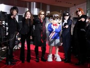 紅に染まったカーペットの上、「真実はいつも一つ」のポーズを決めるX JAPANと、Xポーズを披露する江戸川コナン。