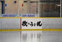 スケートリンクの壁面に掲出された「牧のうどん」の広告。