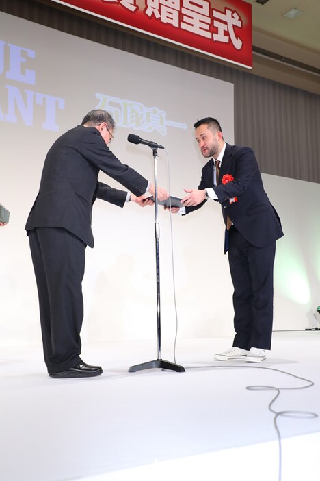 石塚真一（右）の贈呈式の様子。